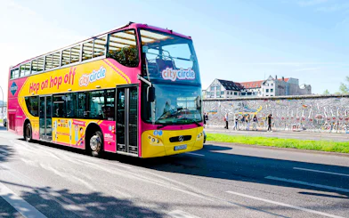 City Circle bus passing by the Berlin Wall with colorful murals.