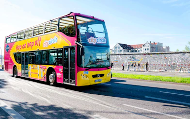 City Circle bus passing by the Berlin Wall with colorful murals.