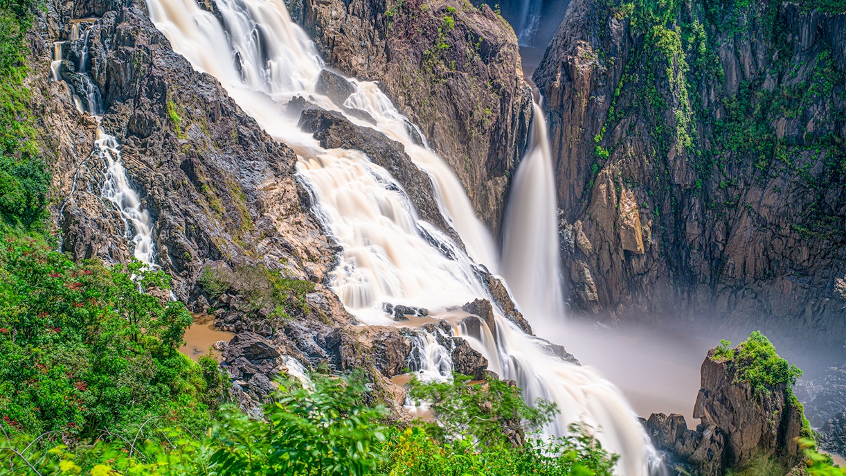 Barron Falls cascading through lush rainforest near Kuranda Scenic Railway, Queensland.