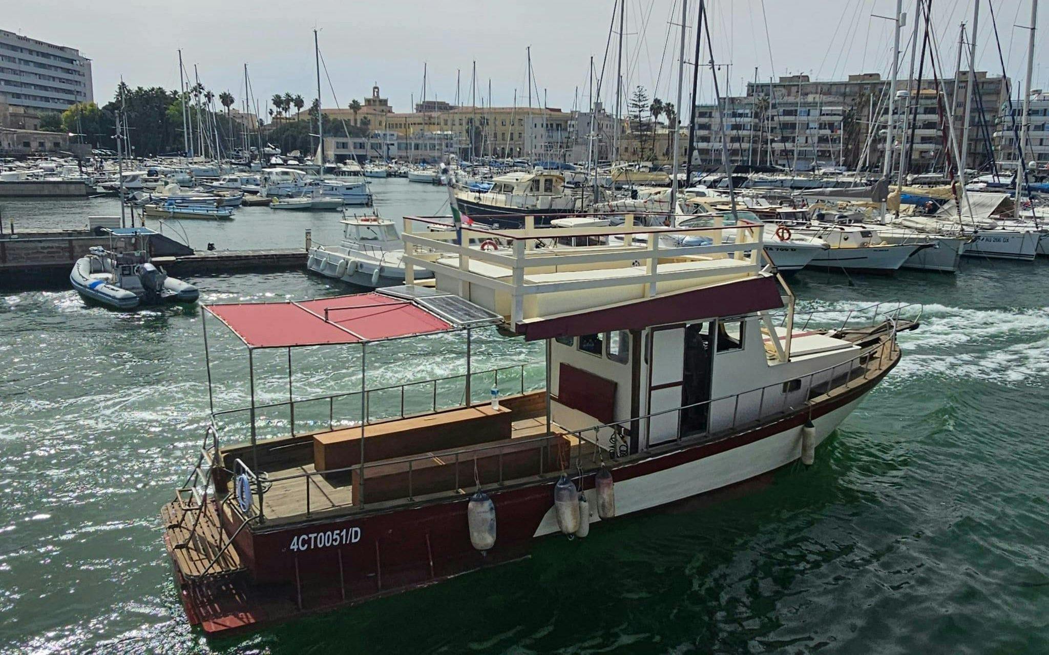 Boat in Ortigia harbor for sunset tour with aperitif on board.