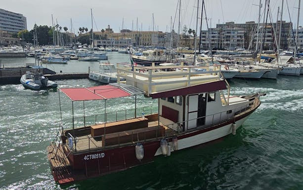 Boat in Ortigia harbor for sunset tour with aperitif on board.