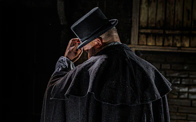 Man in dark cloak and top hat, representing Jack the Ripper at London Dungeon.