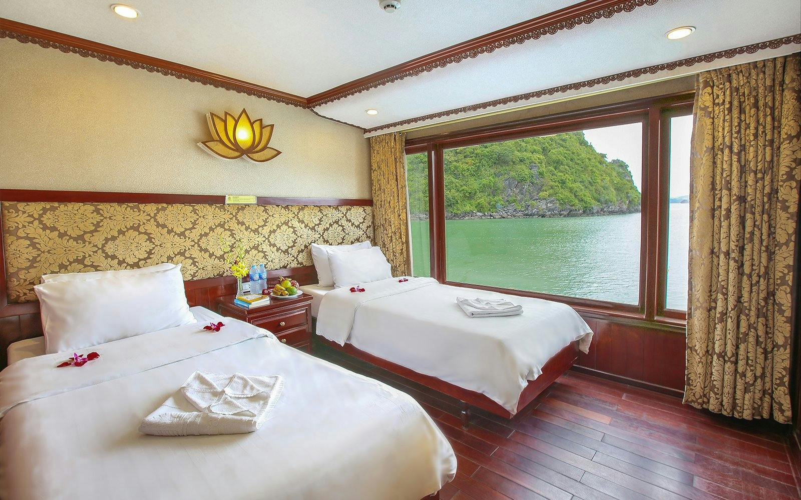 Twin cabin with large window view of Halong Bay on a 3-star cruise.