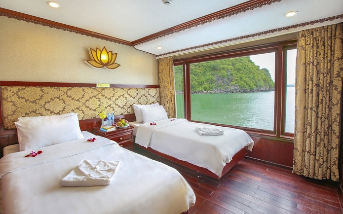Twin cabin with large window view of Halong Bay on a 3-star cruise.
