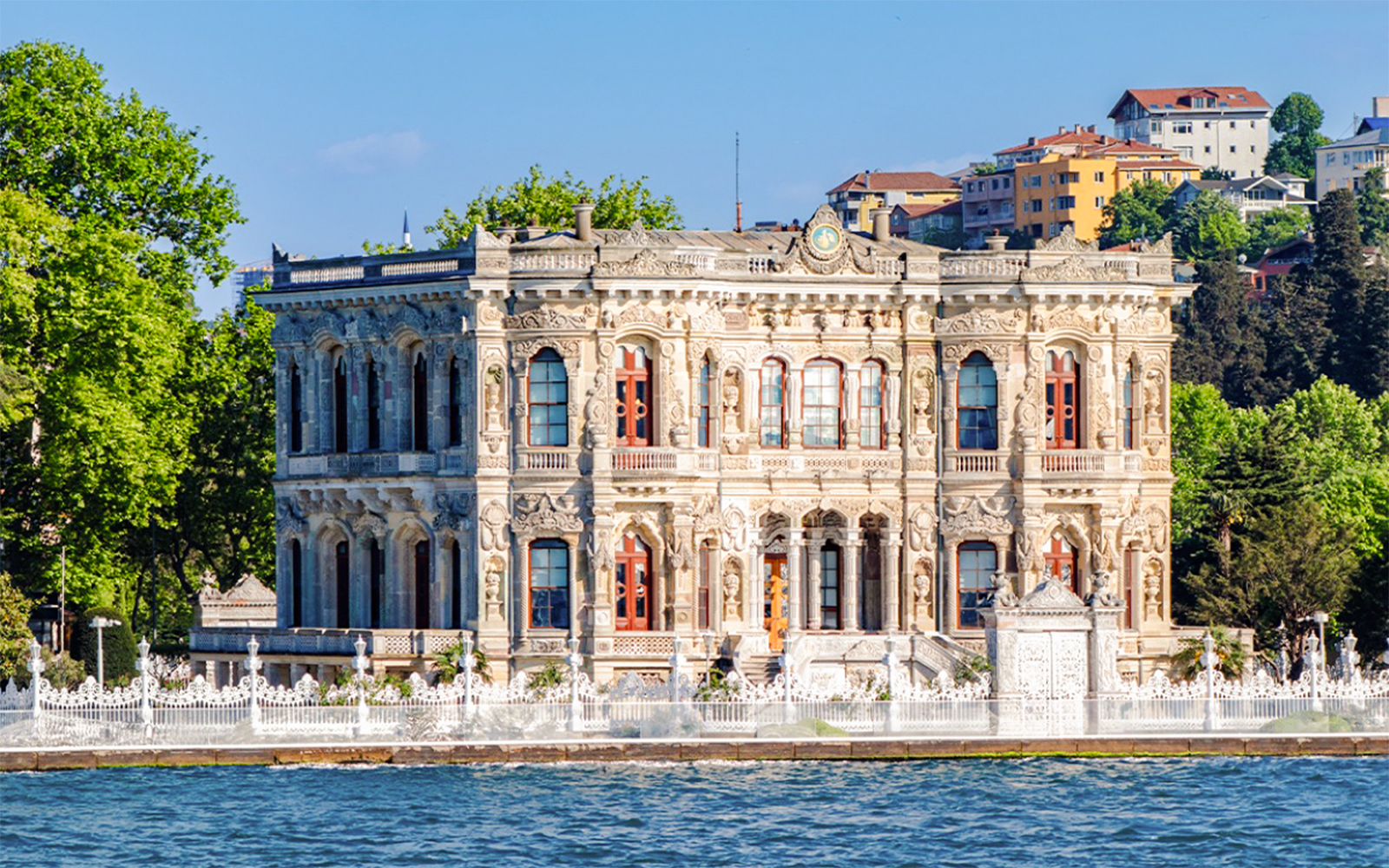 Kucuksu Pavilion by the Bosphorus in Istanbul, surrounded by trees and historic architecture.