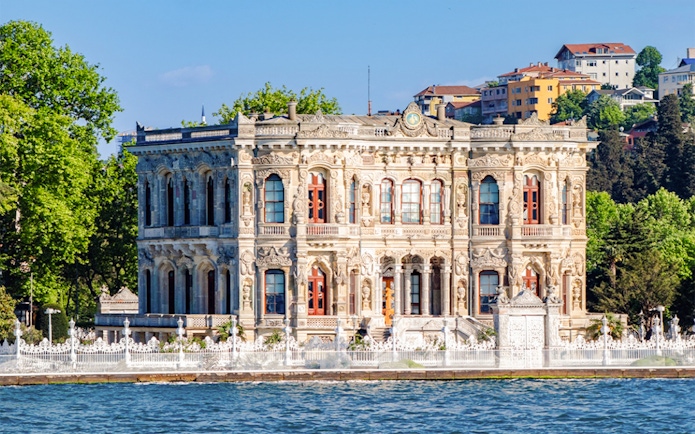 Kucuksu Pavilion by the Bosphorus in Istanbul, surrounded by trees and historic architecture.