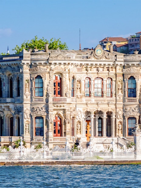 Kucuksu Pavilion by the Bosphorus in Istanbul, surrounded by trees and historic architecture.