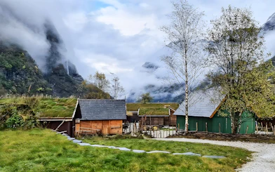 Viking village with grass-roofed houses in a misty valley near Bergen, Norway.