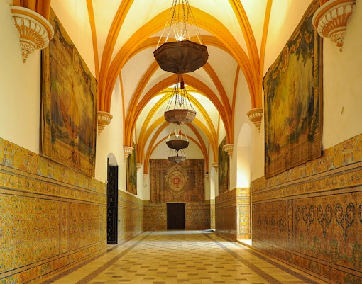 Gothic hall with intricate arches in the Alcázar of Seville, Andalusia, Spain.