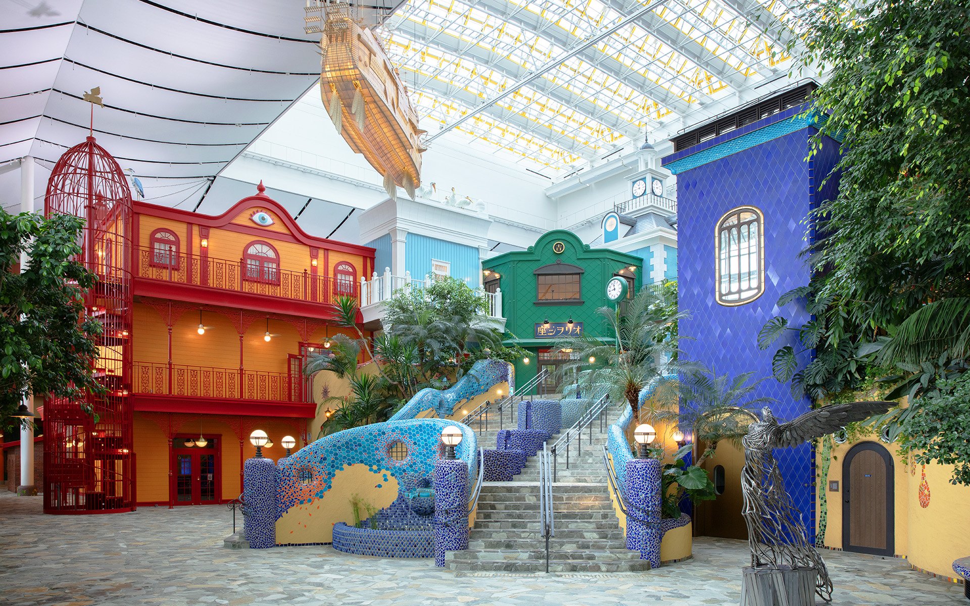 Ghibli's Grand Warehouse colorful buildings and staircase with lush greenery.