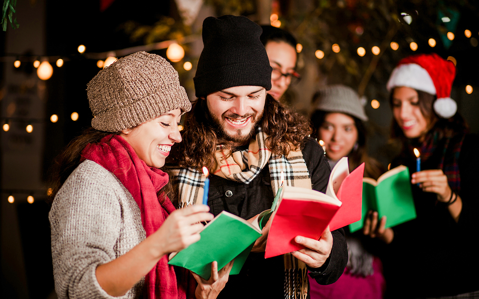 Group singing Christmas carols at Prague Castle with festive lights.