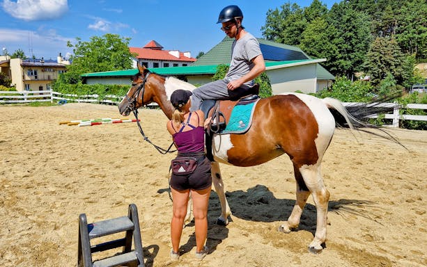 Horse riding lesson preparation in Krakow with a rider mounting a horse.