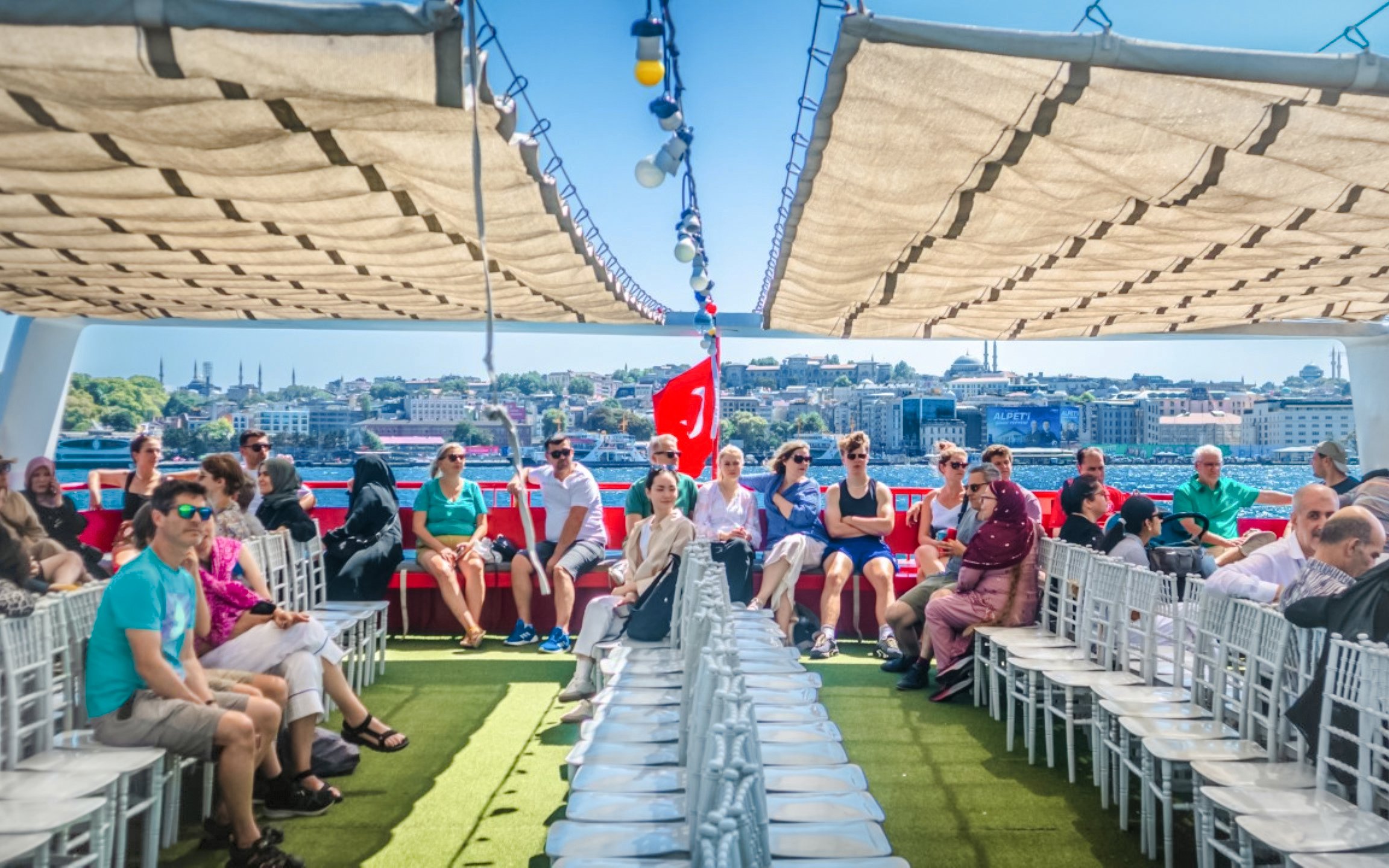 Guests on a Bosphorus sightseeing cruise with Istanbul skyline in the background.