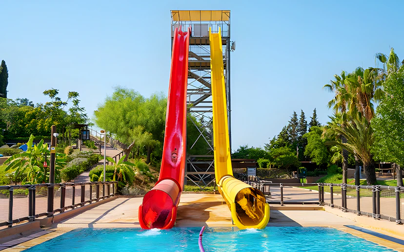 Kamikaze slide at Aquopolis Torrevieja with red and yellow slides leading into a pool.
