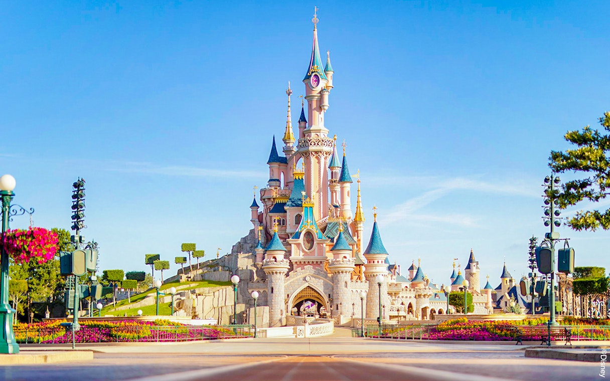 Sleeping Beauty Castle at Disneyland Paris with clear blue sky.