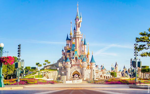 Sleeping Beauty Castle at Disneyland Paris with clear blue sky.