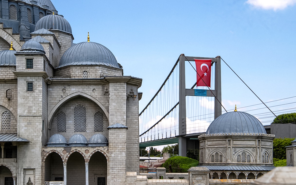 Guests exploring Istanbul Miniatürk with model of mosque and Bosphorus Bridge.