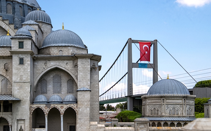 Guests exploring Istanbul Miniatürk with model of mosque and Bosphorus Bridge.