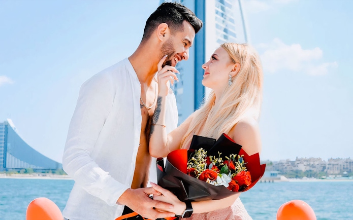 Couple on private yacht with Burj Al Arab in background, Dubai.