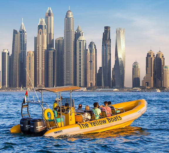 Yellow boat tour near Atlantis Hotel, Dubai, with guide and passengers on board.