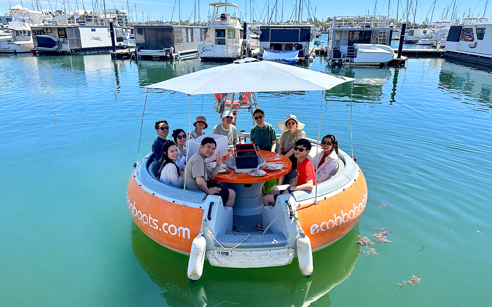 People enjoying a self-drive electric BBQ boat tour in Mandurah marina.