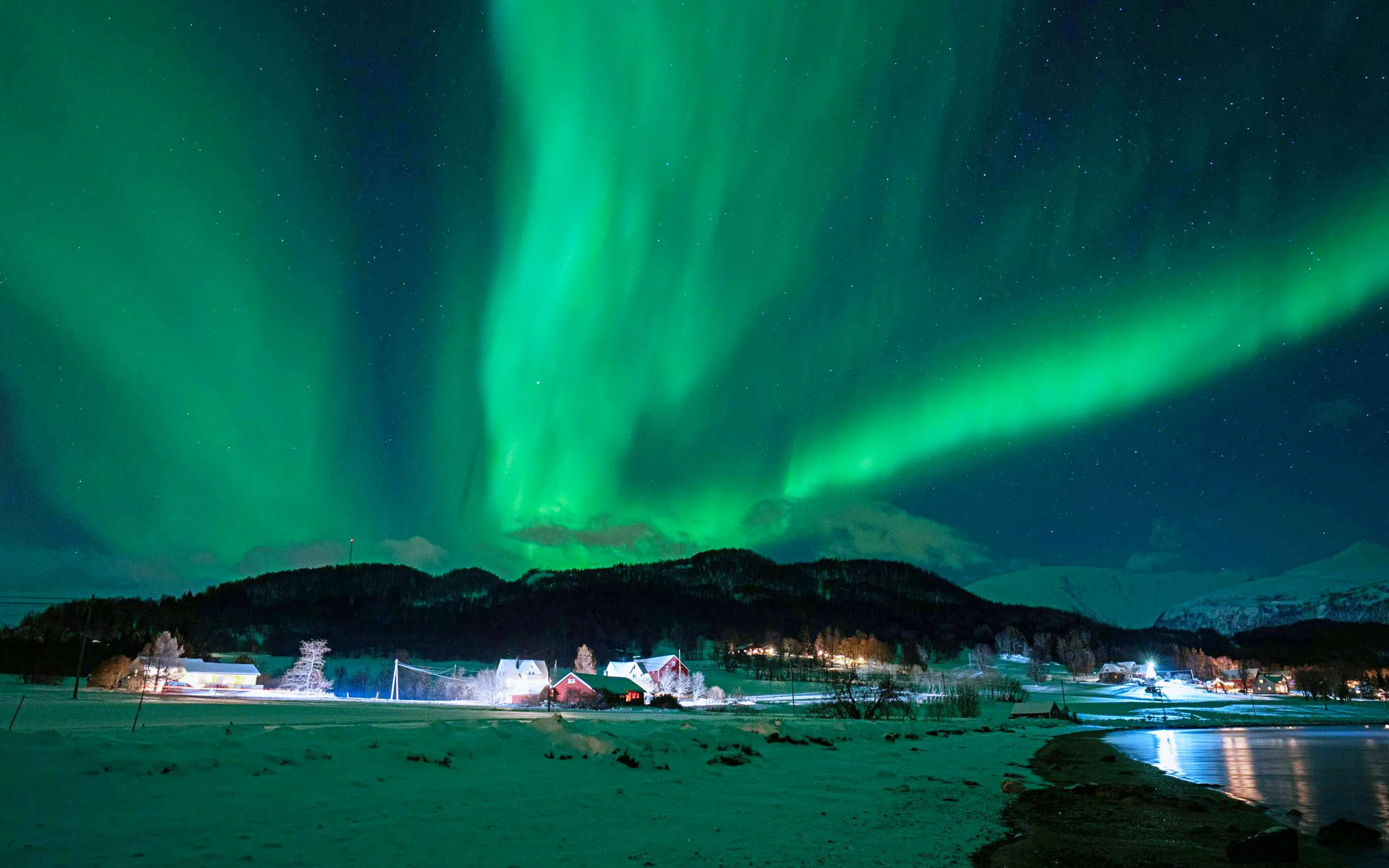 Northern Lights over snowy landscape in Tromso during small group tour.