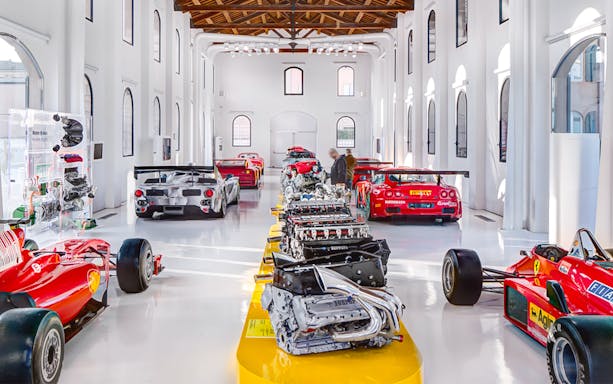 Ferrari engines and race cars displayed at Enzo Ferrari House Museum in Modena, Italy.