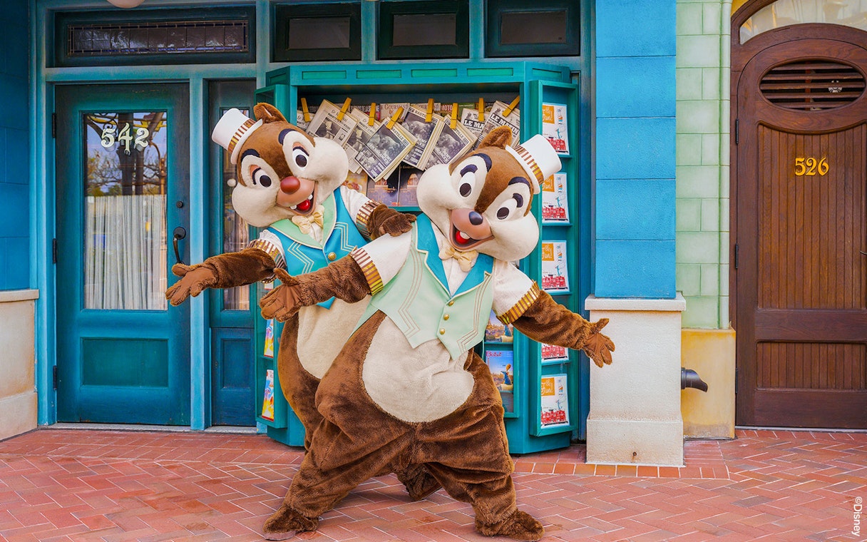 Chip and Dale posing in front of a Disney theme park storefront.