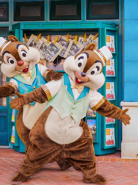Chip and Dale posing in front of a Disney theme park storefront.