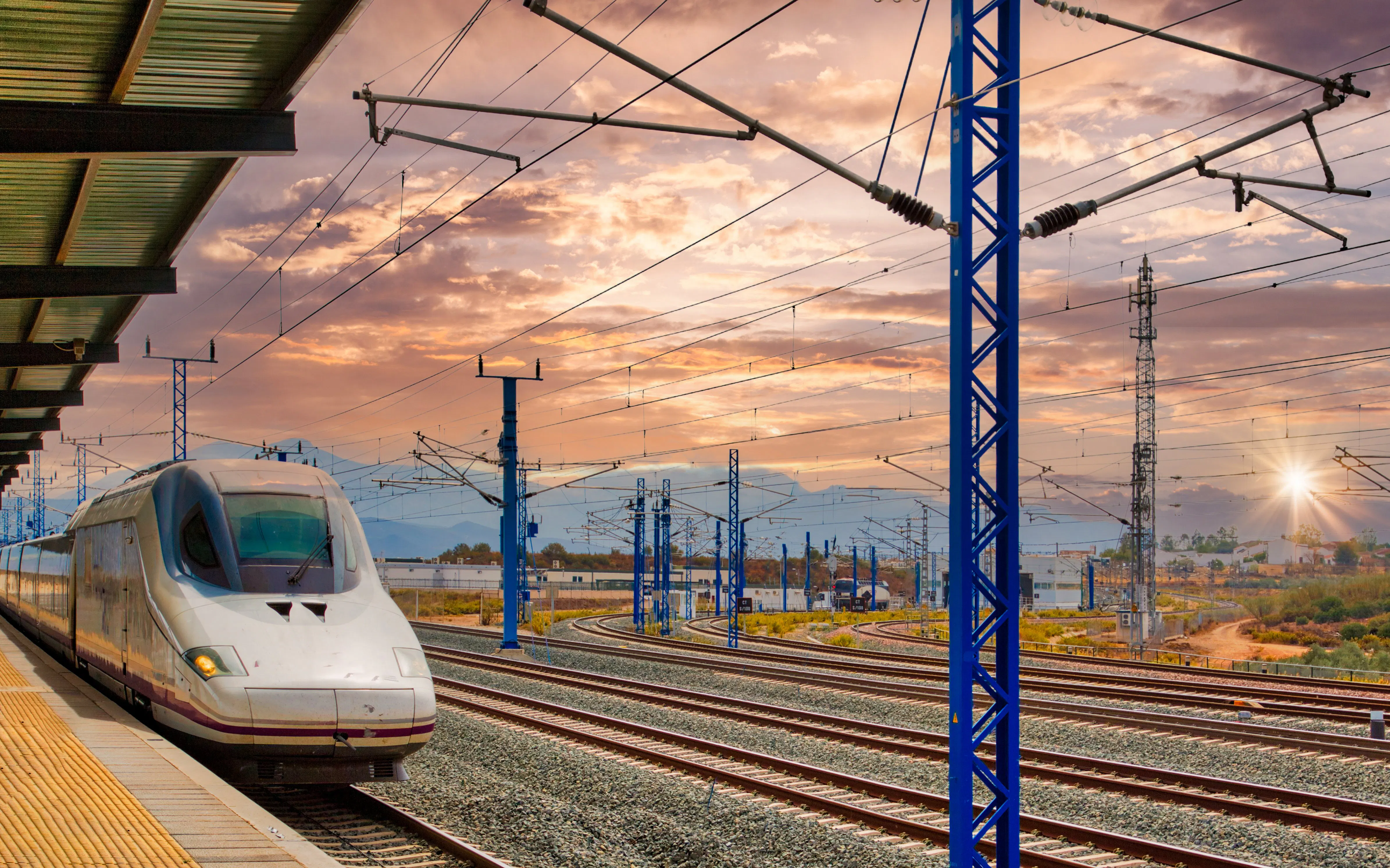 High-speed train at a station in Seville, Spain during sunset.