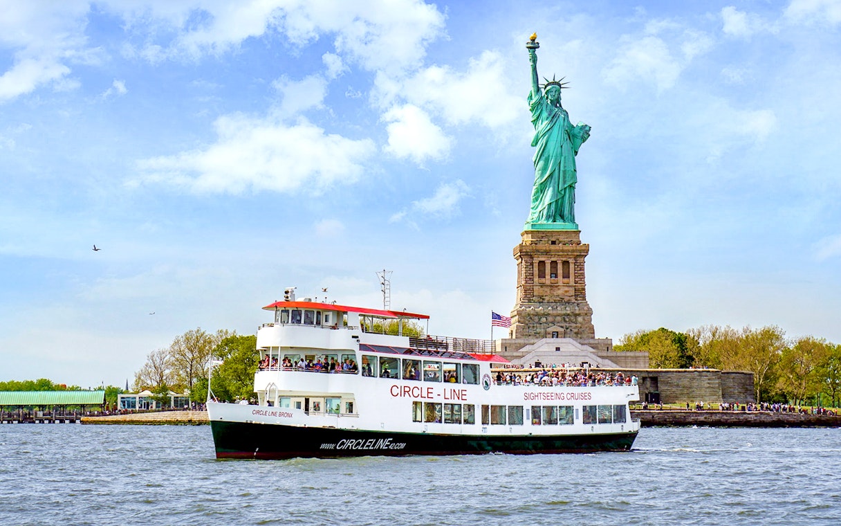 Sightseeing cruise boat near the Statue of Liberty in New York Harbor.