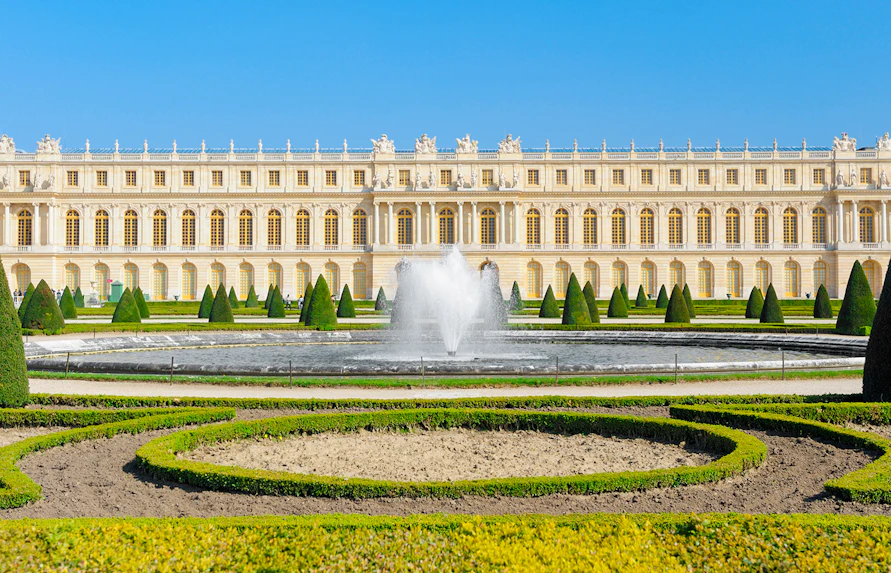 Palace of Versailles front view with fountain and gardens in France.
