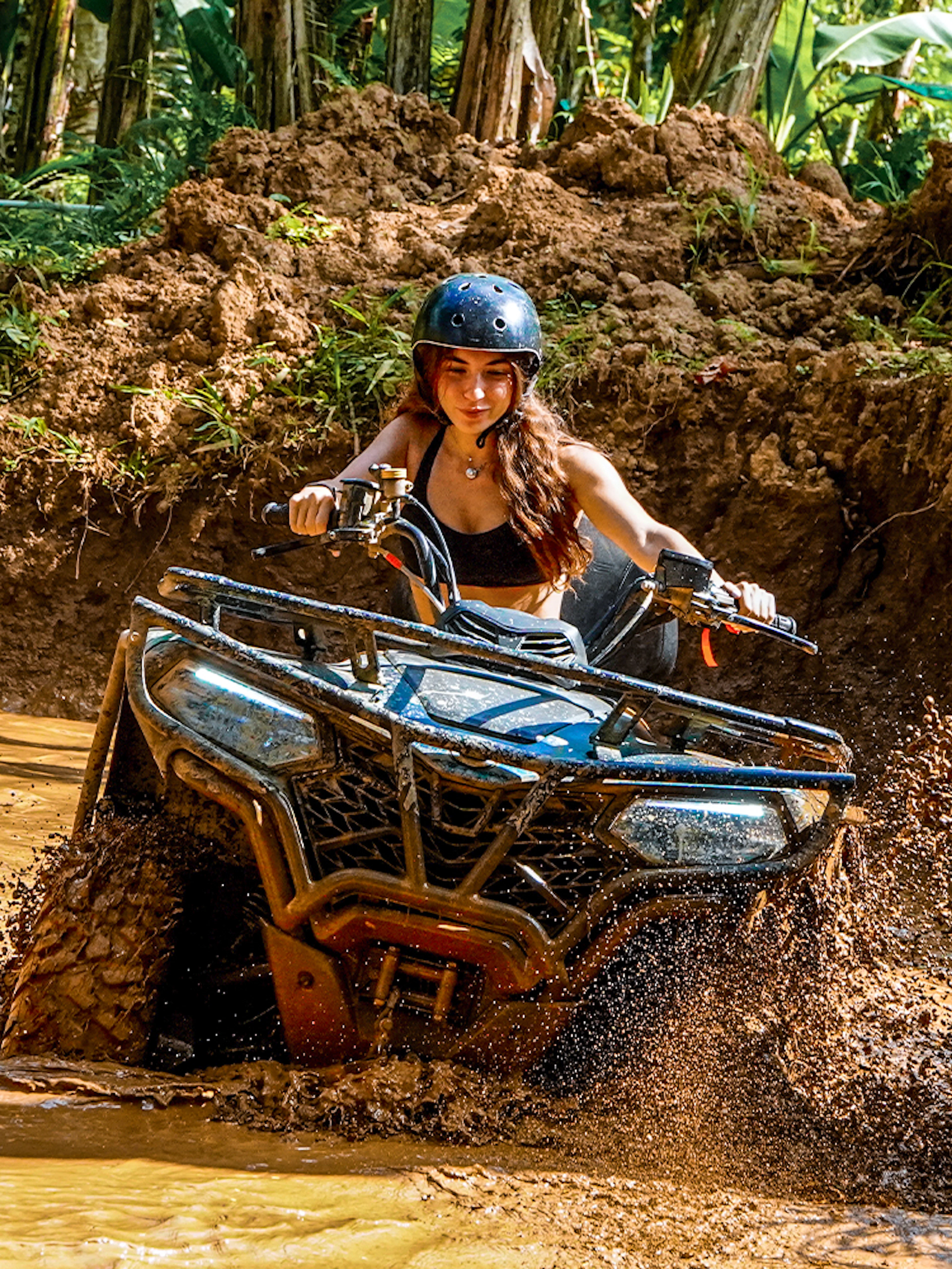 ATV rider navigating muddy terrain in Ubud jungle.