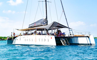 Catamaran with passengers on a sunset open bar tour in Cartagena, sailing on blue waters.