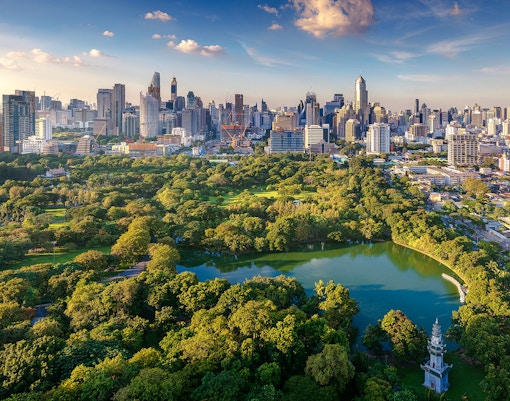 Lumphini Park with Bangkok skyline in the background, Thailand.