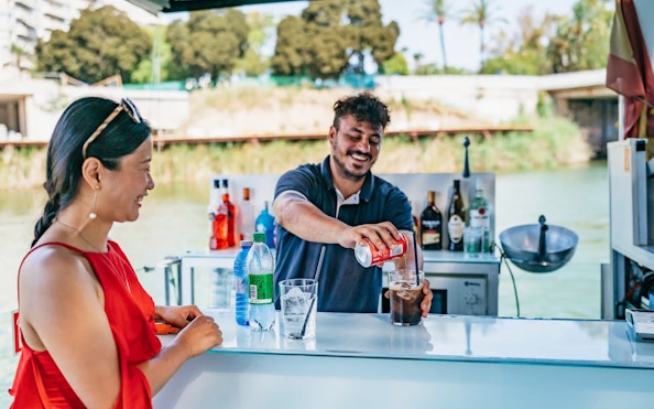 Tourist at live bar on Eco-Friendly Guadalquivir River Cruise, Seville, Spain.