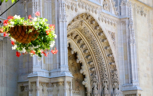 Ornate entrance of Zagreb Cathedral with hanging flower basket.