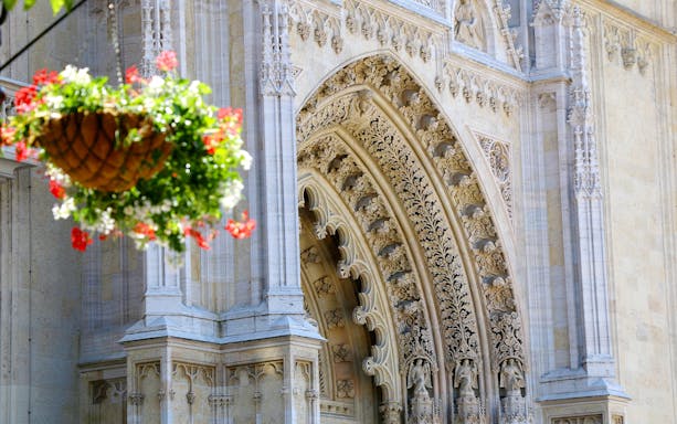 Ornate entrance of Zagreb Cathedral with hanging flower basket.