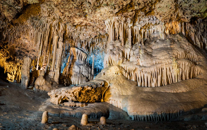 Stalactites and stalagmites in the illuminated interiors of Drach Caves, Mallorca.