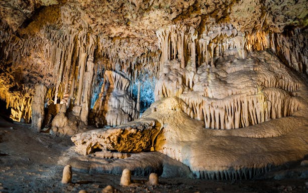 Stalactites and stalagmites in the illuminated interiors of Drach Caves, Mallorca.