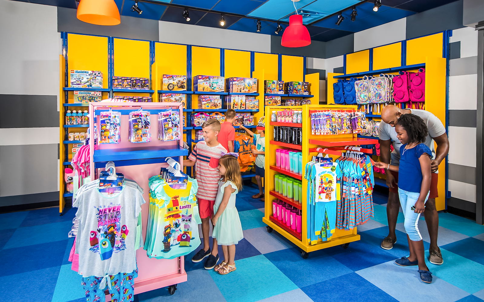 Family shopping at LEGOLAND California store with LEGO merchandise displays.