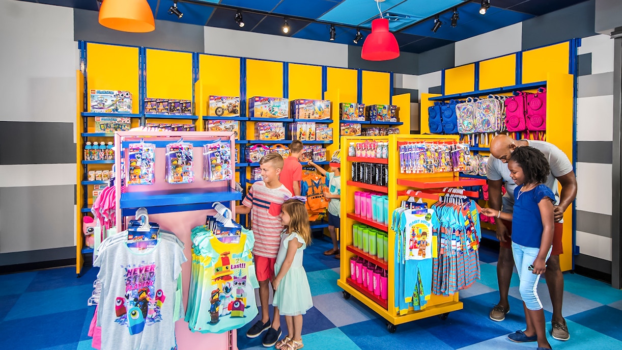 Family shopping at LEGOLAND California store with LEGO merchandise displays.