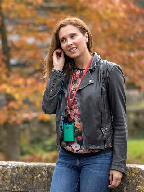 Tourist using personal audio headset during autumn tour.
