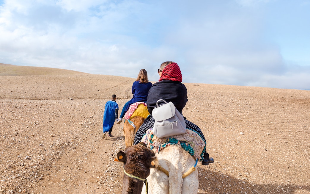 People riding camels in Agafay Desert, Morocco.