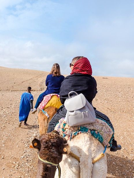 People riding camels in Agafay Desert, Morocco.