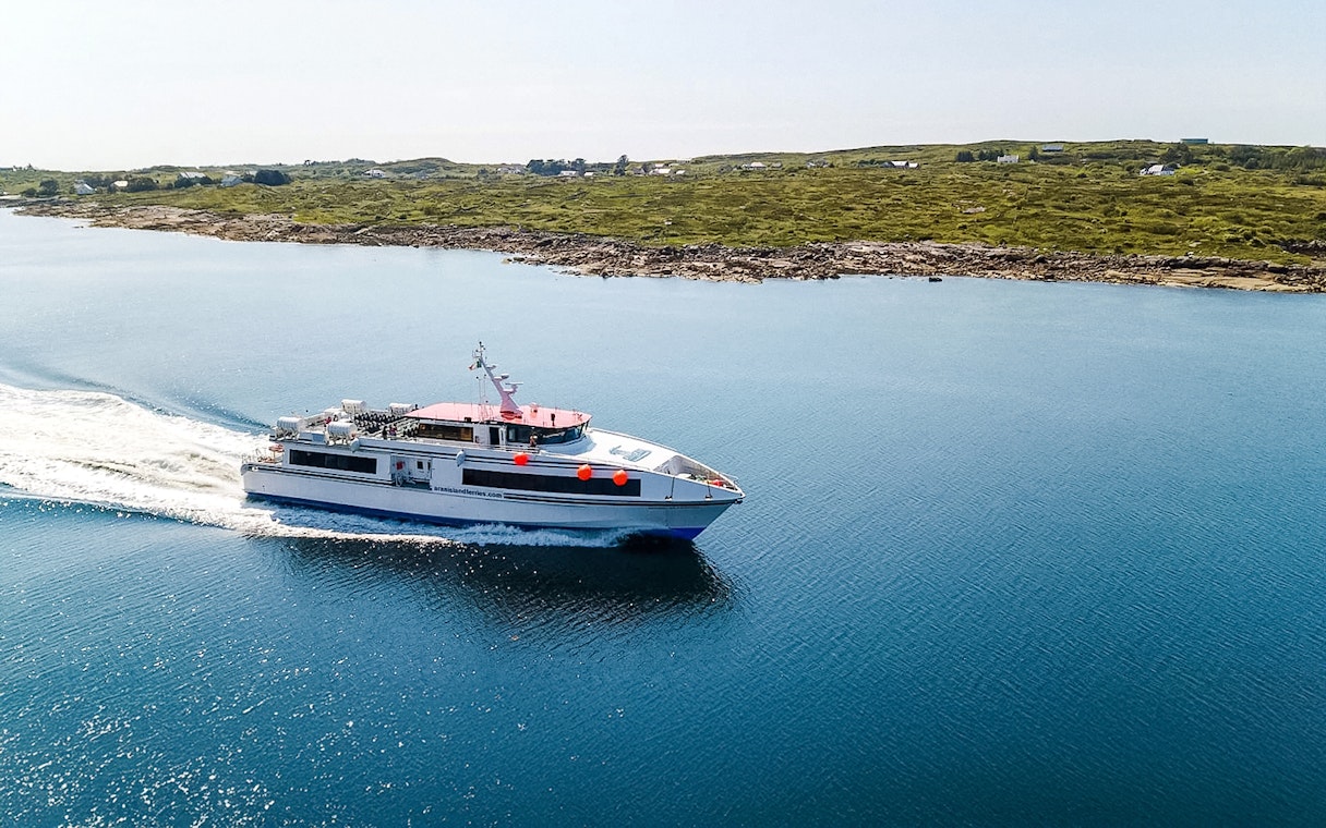 Ferry cruising near the Aran Islands with coastal landscape in the background.