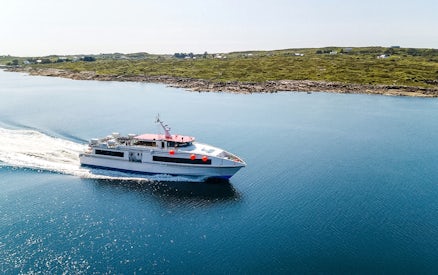 Ferry cruising near the Aran Islands with coastal landscape in the background.