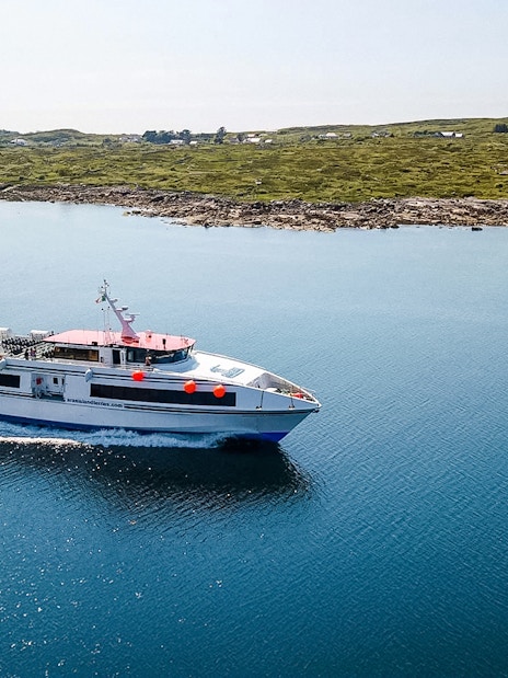 Ferry cruising near the Aran Islands with coastal landscape in the background.