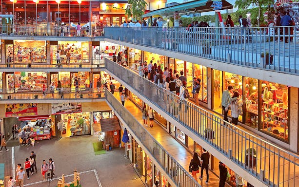 Shoppers exploring vibrant multi-level market in Seoul during guided tour.