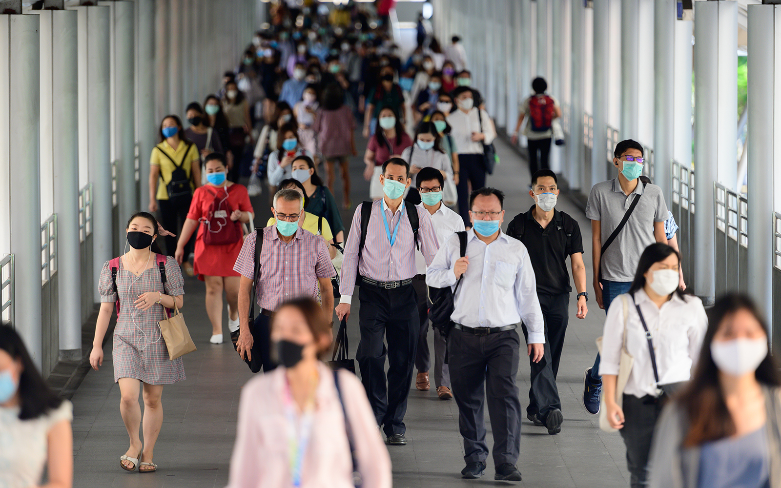 Crowd of people wearing surgical mask and walking